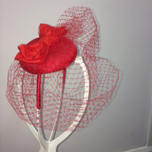Red fascinator on headband with birdcage netting